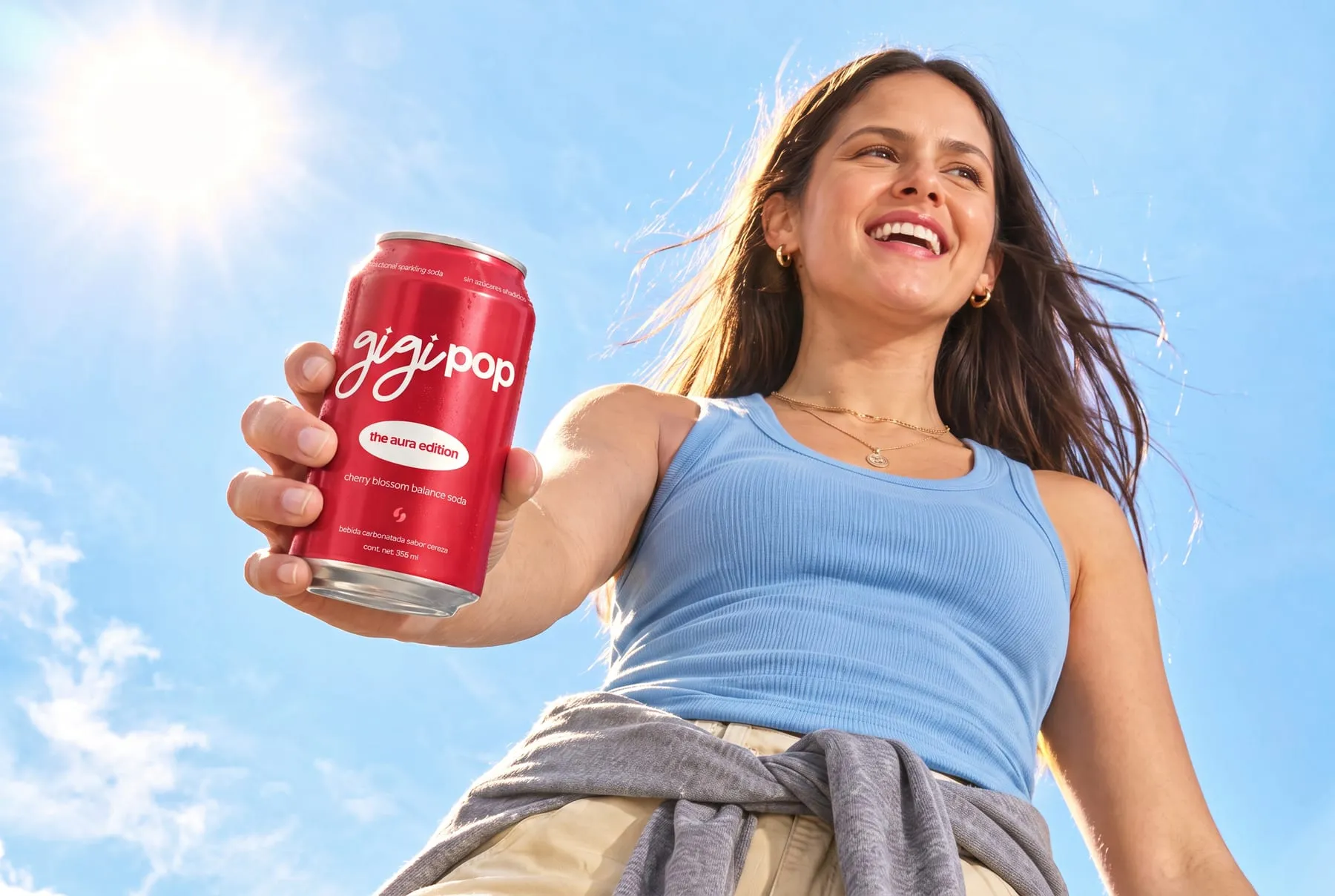 una chica sonriendo con una gigi pop y el cielo de fondo